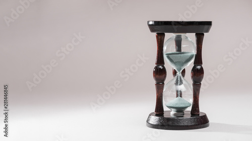 Hourglass as time passing concept for business deadline on colored background