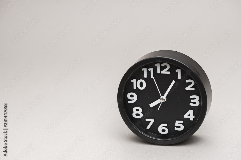 Round black alarm clock against gray background Round black alarm clock against gray background