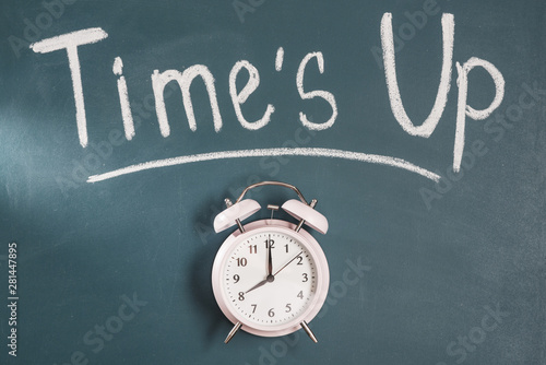 Times up text on green blackboard with alarm clock