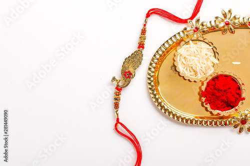 Indian festival Raksha Bandhan , Lord ganesha on Rakhi with rice grains and kumkum on Decorative plate 