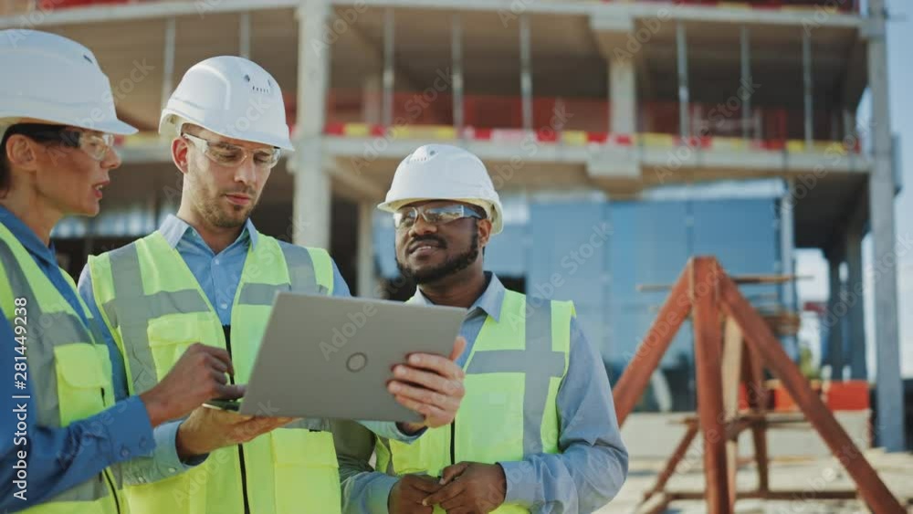 Diverse Team of Specialists Use Laptop Computer on Construction Site. Real Estate Building Project with Engineer, Investor Businesswoman Checking Area, working on Civil Engineering, Discussing Plan. Diverse Team of Specialists Use Laptop Computer on Construction Site. Real Estate Building Project with Engineer, Investor Businesswoman Checking Area, working on Civil Engineering, Discussing Plan.