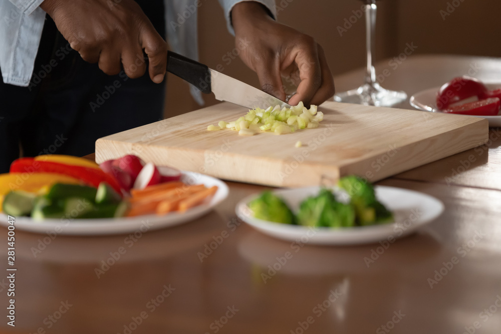 African man chopping vegetables preparing dinner closeup hands