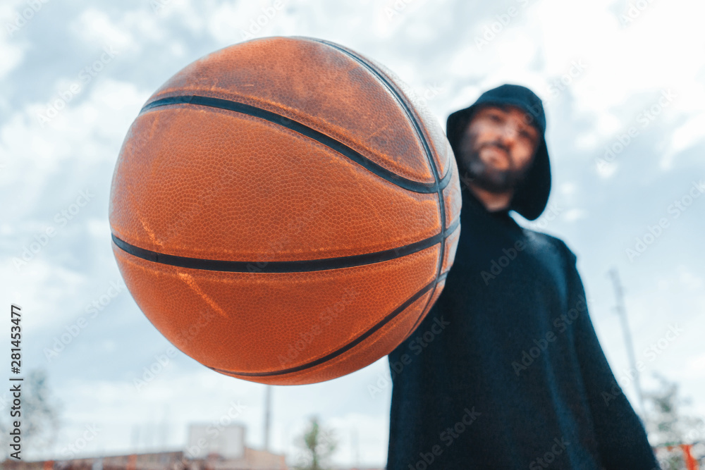 Close up of attractive man holding basket ball. Ball is on focus and foreground. Close up of attractive man holding basket ball. Ball is on focus and foreground.