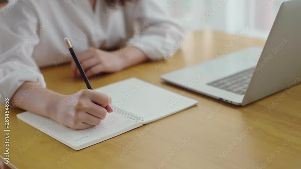Female hand use pencil to writing on notebook Female hand use pencil to writing on notebook
