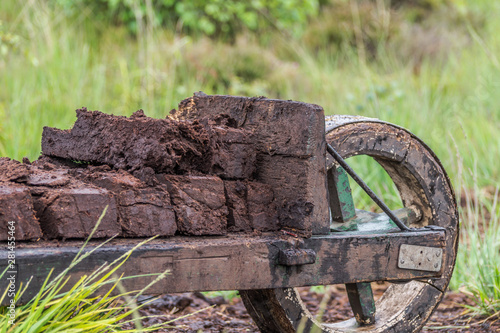 Pile of peat bog turf stacked up on a wooden wheelbarrow at a field in wiesmoor, germany. photo
