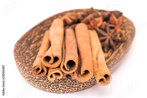 Cinnamon stick and star anise spice on wooden plate isolated on white background 