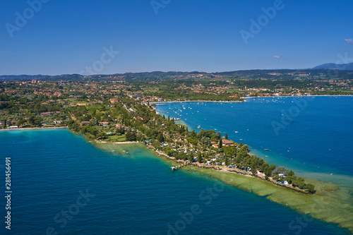 Fototapeta Naklejka Na Ścianę i Meble -  Unique view of the island of San Biagio. In the background is the Alps. Resort place on Lake Garda north of Italy. Aerial photography. 