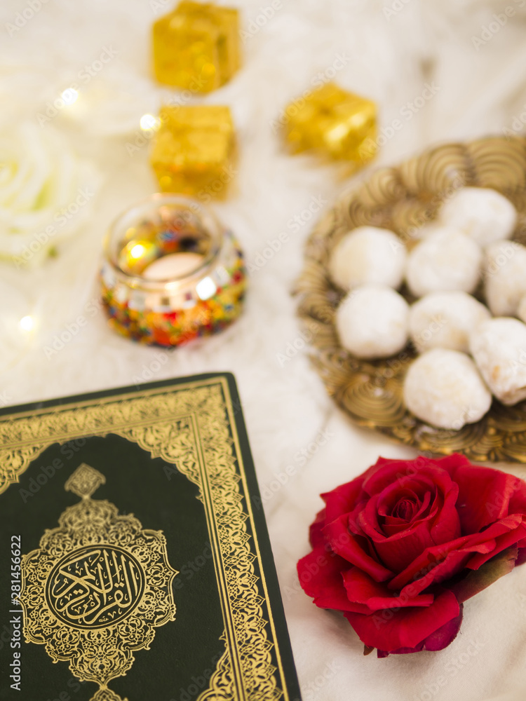 Top view table arrangement with quran, roses and pastries Top view table arrangement with quran, roses and pastries
