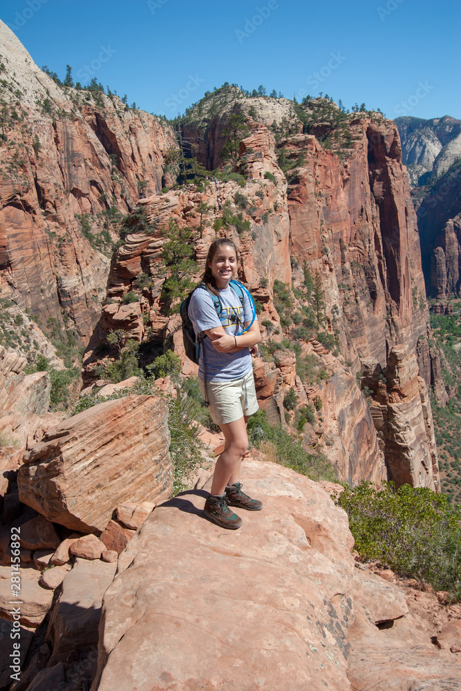 Young girl on the challenging Angels Landing Trail in Zion National Park, Utah on a clear and cloudless summer morning.
