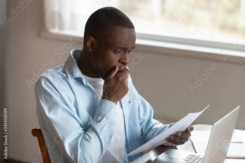 Fotografi African guy holding letter reading shocking unexpected news feels disappointed