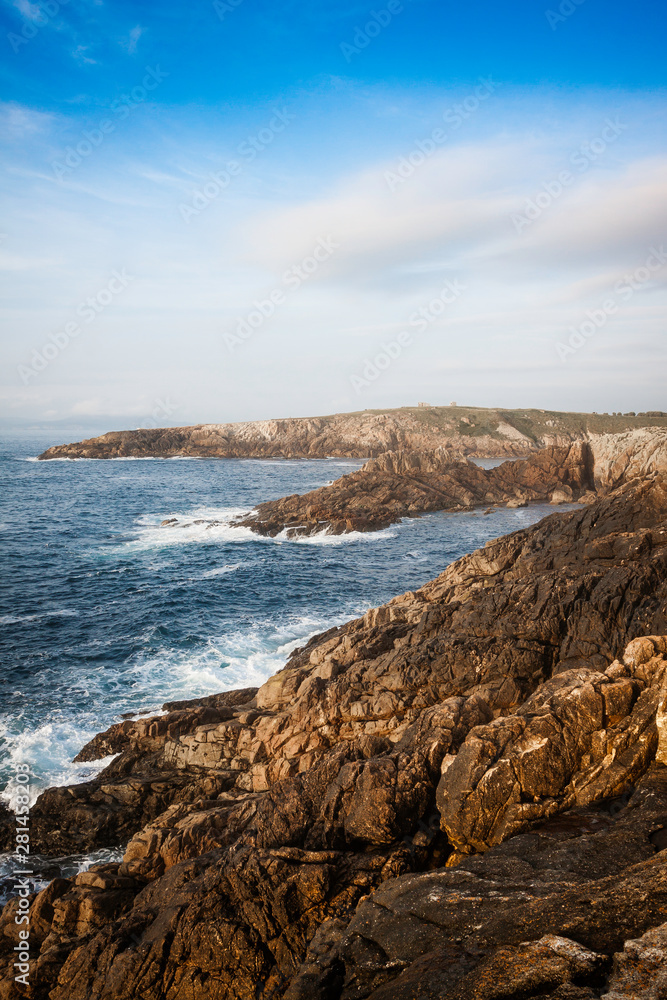 LANDSCAPE OF COAST WITH ROCKS AND SEA AND BLUE SKY HORIZON WITH CLOUDS ON THE COAST OF A CORUÑA IN GALICIA, SPAIN