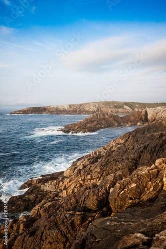 LANDSCAPE OF COAST WITH ROCKS AND SEA AND BLUE SKY HORIZON WITH CLOUDS ON THE COAST OF A CORUÑA IN GALICIA, SPAIN
