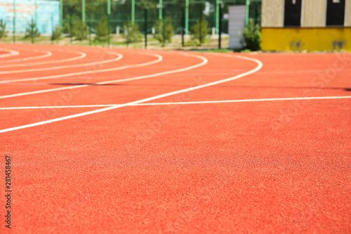 Red running track with white lines outdoor, copy space © Atlas