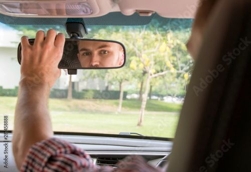 Man adjusting his car mirror.