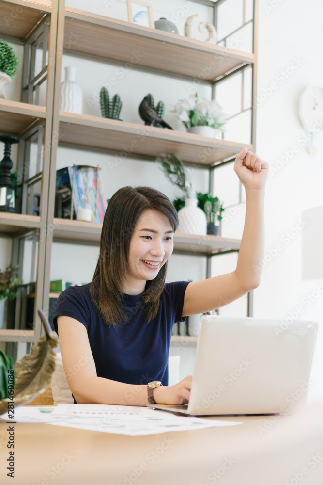 Happy excited successful asian woman while she using computer labtop at her apartment,Lifestyle Concept Happy excited successful asian woman while she using computer labtop at her apartment,Lifestyle Concept
