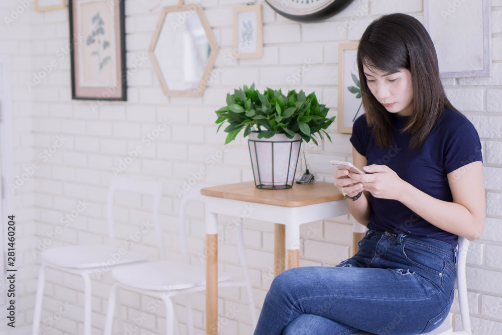 Portrait of pretty asian woman working comfortably and use smartphone at her apartment,Lifestyle Concept