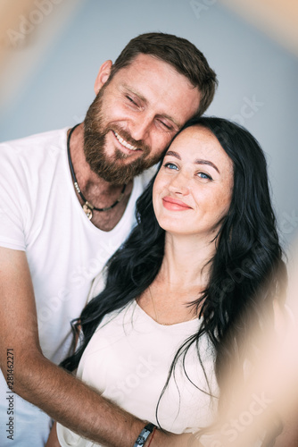 Loving couple woman and man with beard soft light from window