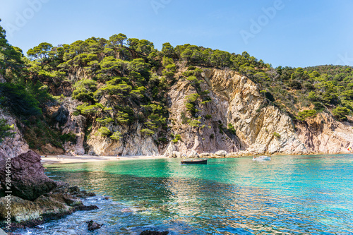 Little beach and two boats on the turquoise water in Costa Brava, Catalonia (Spain)