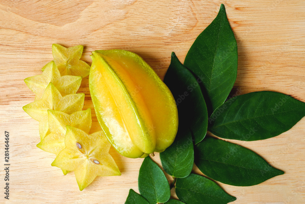 Φωτογραφία Star apple (Carambola, starfruit, Ma fueng, Golden Star, Newcomb, Golden star) on a wooden cutting board