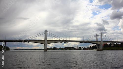 Large bridge across the Volga river in the city of Kimry the Tver region on a summer day on the background of a stormy sky with clouds, panoramic view from the water