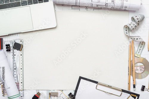 Architectural plans, pencil and ruler on the table. Laptop and accessories. Place for your text.