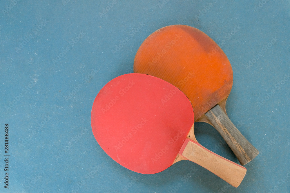 two wooden rackets for table tennis on a blue background,copy space. two wooden rackets for table tennis on a blue background,copy space.