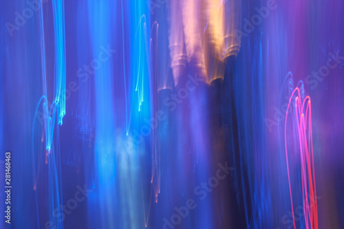 Blurred neon multicolor glow on dark background. Lens flare effect. Night city lights.