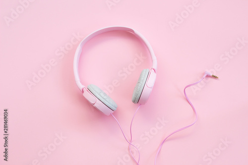 Pink headphones on pink background. Music concept