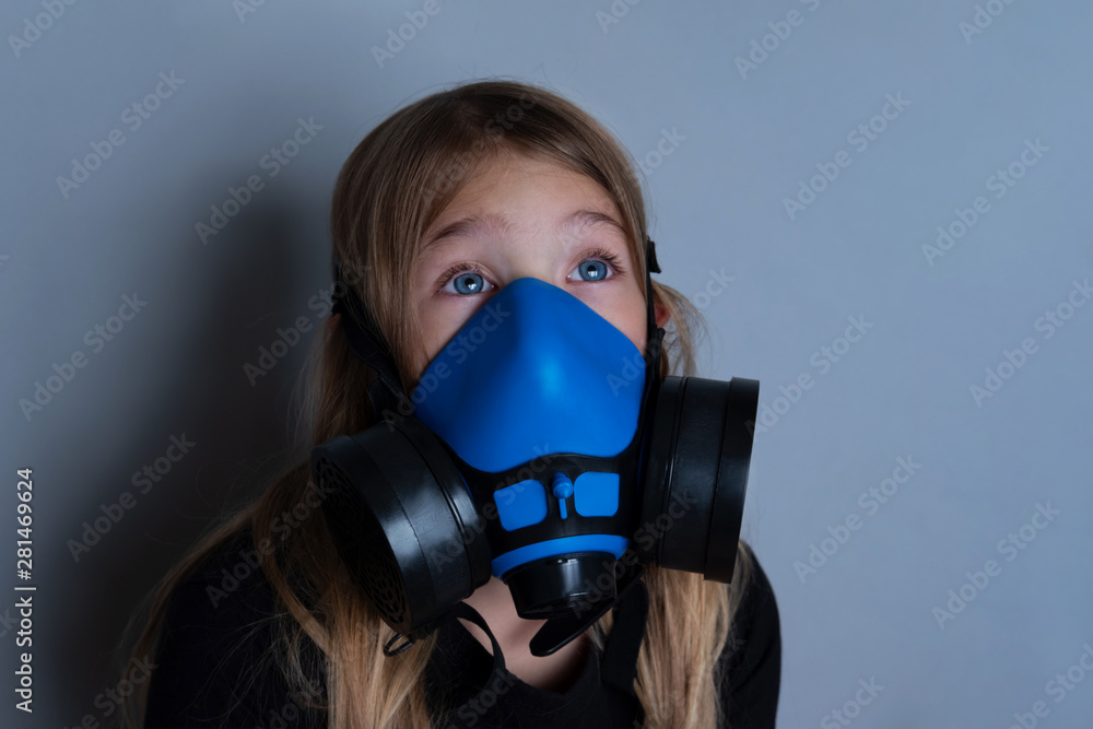 Young girl wearing gasmask, respirator portrait. Effects of worldwide air pollution, industrial influence on environment. Protection from dangerous air particles, gas, smog, transmitted diseases Young girl wearing gasmask, respirator portrait. Effects of worldwide air pollution, industrial influence on environment. Protection from dangerous air particles, gas, smog, transmitted diseases