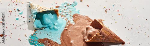 delicious melted chocolate and blue ice cream in waffle cones on marble grey background with sprinkles, panoramic shot © LIGHTFIELD STUDIOS