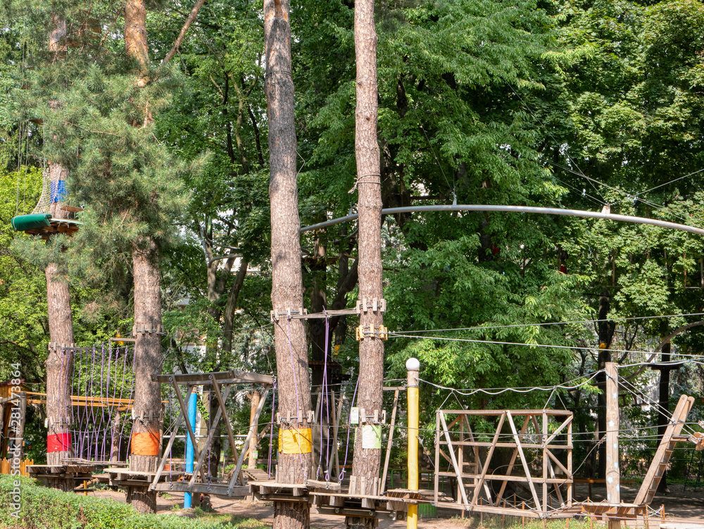 rope climbing amusement adventure park on trees in forest