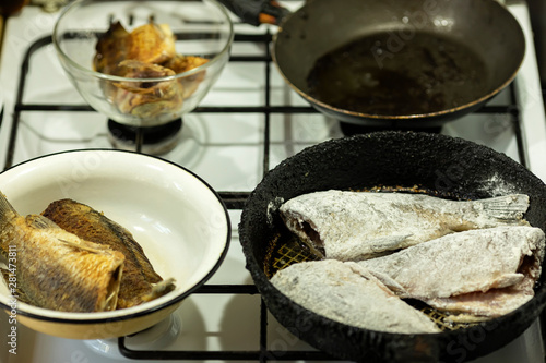 Pieces of river fish are fried in a pan on the stove. Cooking at home.