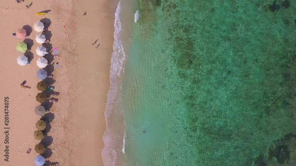 AERIAL 4K: Lock down view of people enjoying the summer at sandy beach line, waves breaking against the coastal line AERIAL 4K: Lock down view of people enjoying the summer at sandy beach line, waves breaking against the coastal line