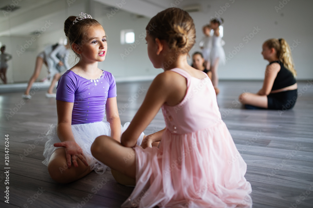 Naklejka premium Group of fit happy children exercising ballet in studio together