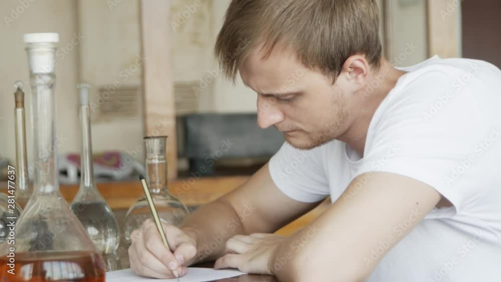 High school / university student in an exam in chemistry classroom. Close up portrait. High school / university student in an exam in chemistry classroom. Close up portrait.