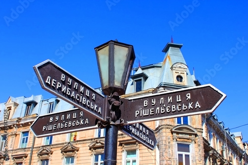 Old lantern with street signs to famous Deribasovskaya street in downtown Odessa, Ukraine © Gelia