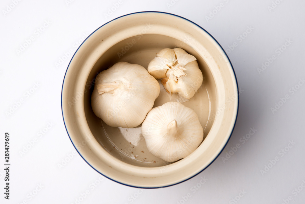 bowl container with three garlic bulbs