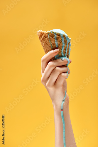 Valokuvatapetti cropped view of woman holding delicious melted blue ice cream in crispy waffle c