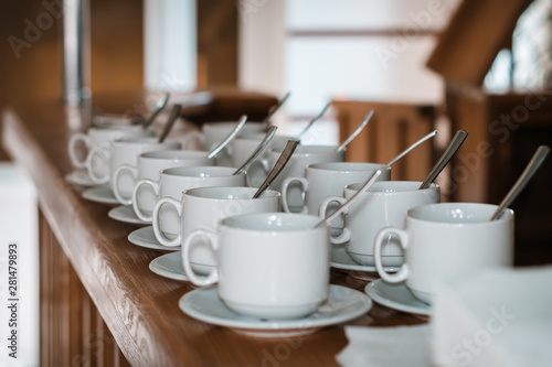 Cups with spoons for tea on a wooden table in a cafe