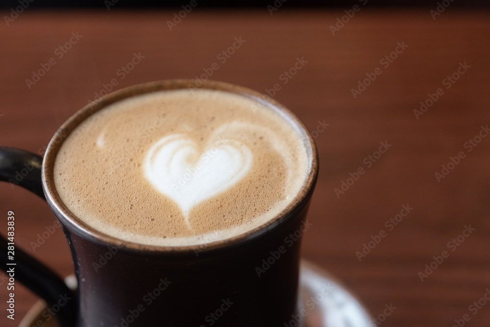 Coffee cup with latte art foam on wood table in coffee shop with copy space.Coffee is one of the most popular beverages.Improve Energy Levels and Burn Fat Coffee cup with latte art foam on wood table in coffee shop with copy space.Coffee is one of the most popular beverages.Improve Energy Levels and Burn Fat