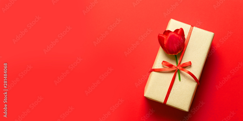 Top view of wrapped spring gift boxes with red ribbons on red table top. Top view of wrapped spring gift boxes with red ribbons on red table top.