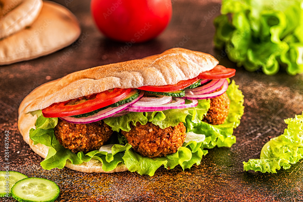Falafel and fresh vegetables in pita bread. Stock Photo | Adobe Stock