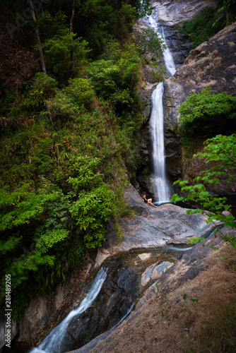 Woman hiker sitting near Mae Pan waterfall in Doi Inthanon National Park near Chiang Mai