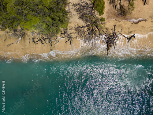 Drone top down view of the crystal clear water, crashing waves, and natural beachs of the Lahaina Coast on the island of Maui, Hawaii
