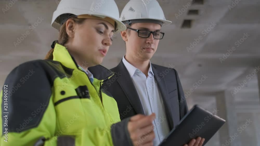 Architect or engineer working, browsing building project indoor of construction site with blueprint plan. businessman worker, man male construction engineers or architects working people. Two Engineer Architect or engineer working, browsing building project indoor of construction site with blueprint plan. businessman worker, man male construction engineers or architects working people. Two Engineer