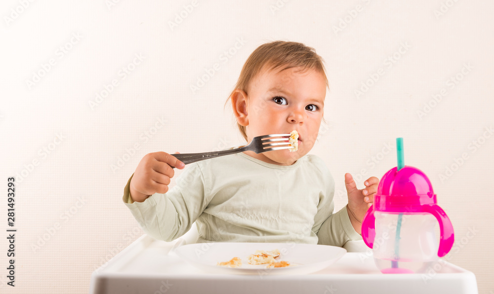 Baby toddler eating pancakes with fork. Isolated. Copy space Baby toddler eating pancakes with fork. Isolated. Copy space