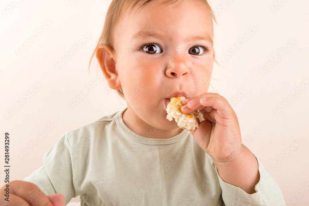 Baby toddler eats food with fingers. Fun face. Copy space Baby toddler eats food with fingers. Fun face. Copy space