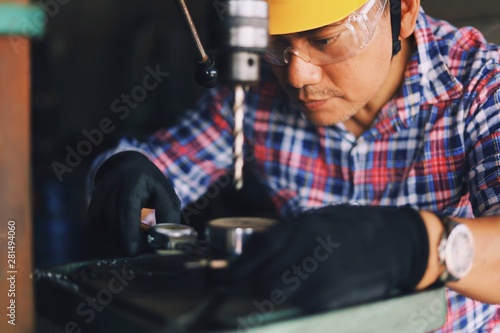 Smart Senior Asian man Engineering fixing machine in factory. 
