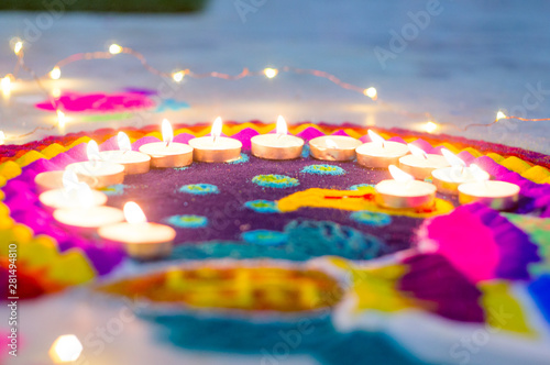 Foto Beautiful rangoli made from colored powders and decorated with wax candle diyas