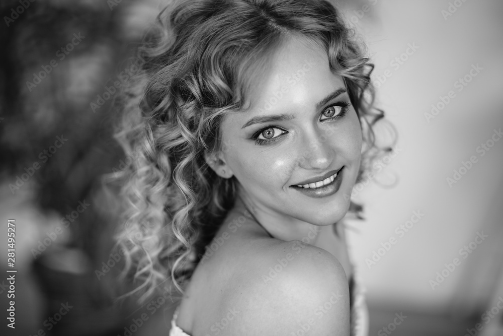 Naklejka premium Close up portrait of blonde charming young woman with curly hair and natural makeup. Sunny morning, spa and care
